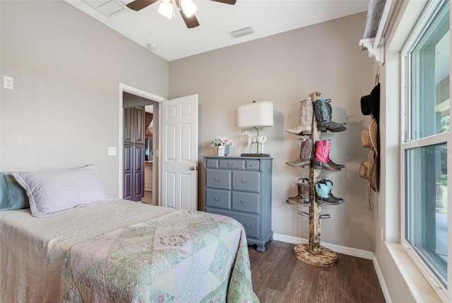 bedroom featuring a ceiling fan, wood finished floors, visible vents, and baseboards