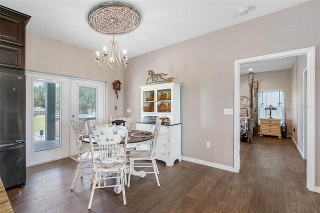 dining area featuring dark wood-type flooring, french doors, and a notable chandelier