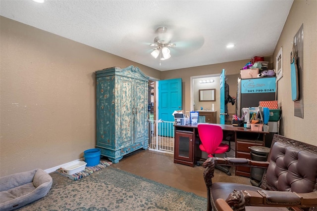 home office with a textured ceiling, concrete floors, and ceiling fan