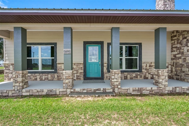 entrance to property featuring stone siding and covered porch