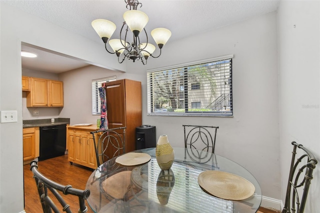 dining room with dark wood-type flooring, a notable chandelier, and a textured ceiling