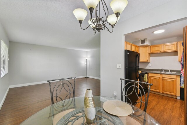 dining space with sink, a chandelier, dark hardwood / wood-style flooring, and a textured ceiling