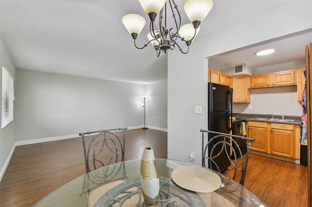 dining room featuring dark wood-style flooring, visible vents, a notable chandelier, and baseboards