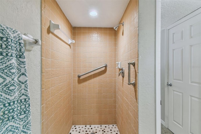 bathroom featuring a stall shower and a textured wall