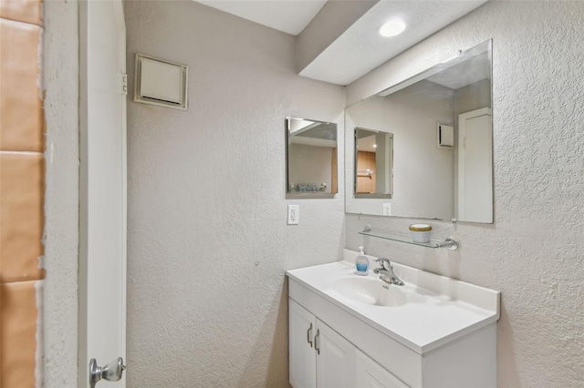 bathroom with vanity and a textured wall