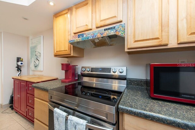 kitchen with appliances with stainless steel finishes, light tile patterned floors, and light brown cabinetry