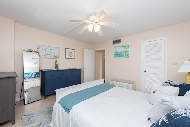 tiled bedroom featuring ceiling fan and a closet