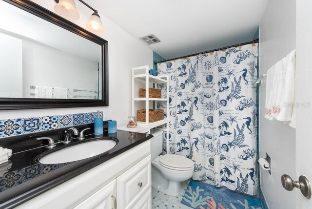 bathroom featuring walk in shower, vanity, and toilet