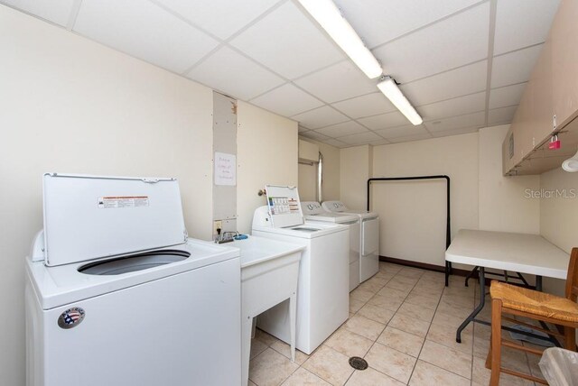 clothes washing area featuring light tile patterned floors and washer and dryer