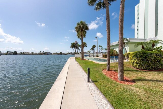 view of home's community with a water view and a yard