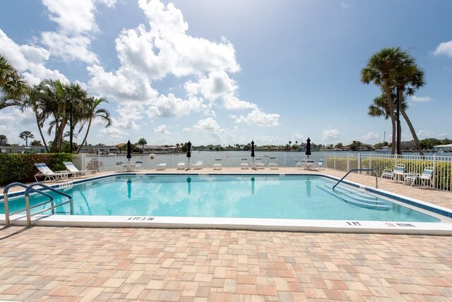 view of pool with a patio area and a water view