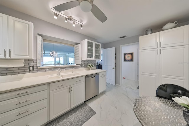 kitchen with dishwasher, sink, white cabinets, and decorative backsplash