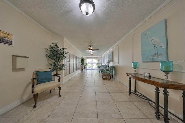 hallway with ornamental molding, a textured ceiling, and light tile patterned floors