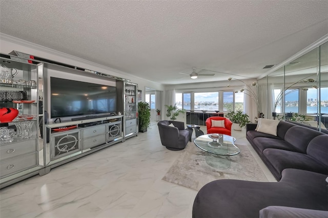 living room with a water view, ceiling fan, ornamental molding, and a textured ceiling