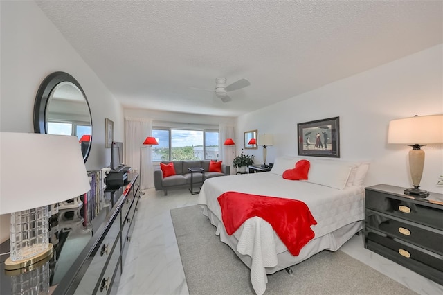 bedroom with ceiling fan and a textured ceiling