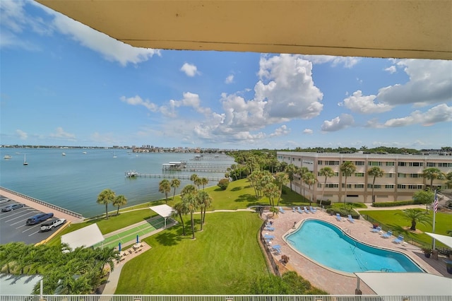 view of pool featuring a water view and a yard