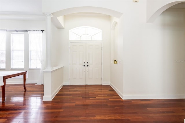 entryway with ornamental molding, ornate columns, and wood-type flooring