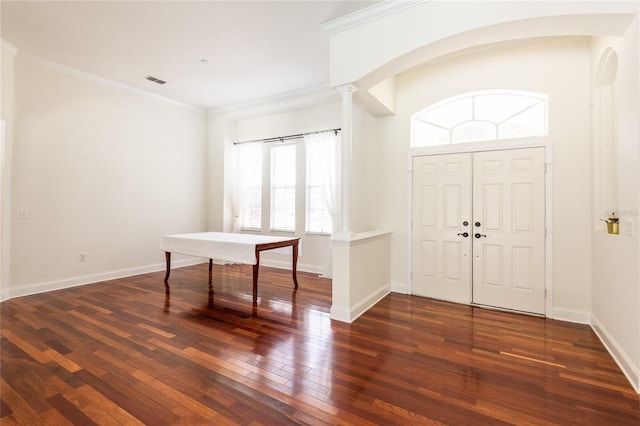 foyer entrance with crown molding, dark wood-type flooring, and decorative columns