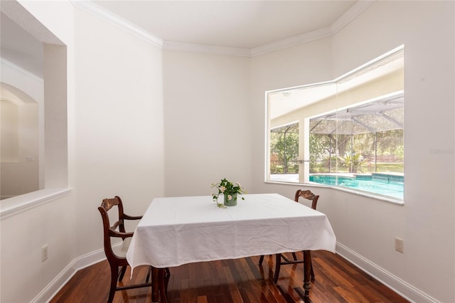 dining area with ornamental molding and dark hardwood / wood-style flooring