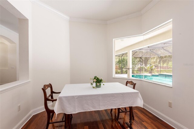 dining area featuring ornamental molding and dark hardwood / wood-style floors