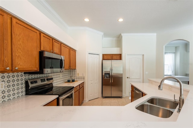 kitchen with sink, crown molding, stainless steel appliances, light tile patterned flooring, and decorative backsplash