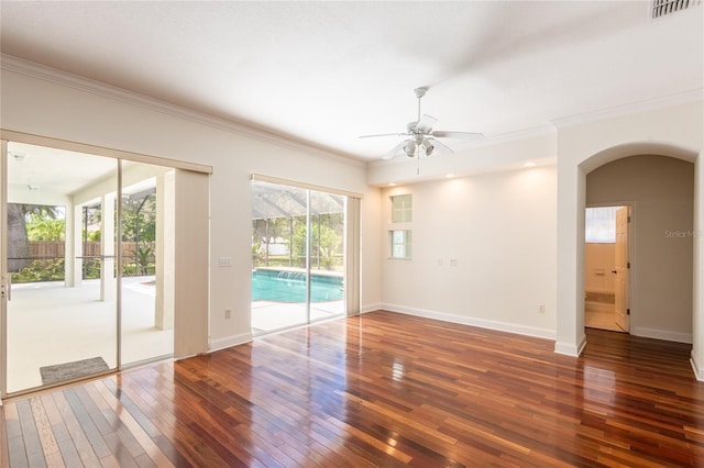 empty room with plenty of natural light, ceiling fan, hardwood / wood-style flooring, and ornamental molding