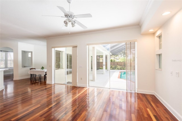 unfurnished room with crown molding, plenty of natural light, dark hardwood / wood-style floors, and ceiling fan