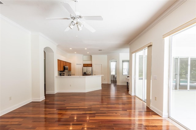 unfurnished living room featuring hardwood / wood-style flooring, crown molding, and ceiling fan