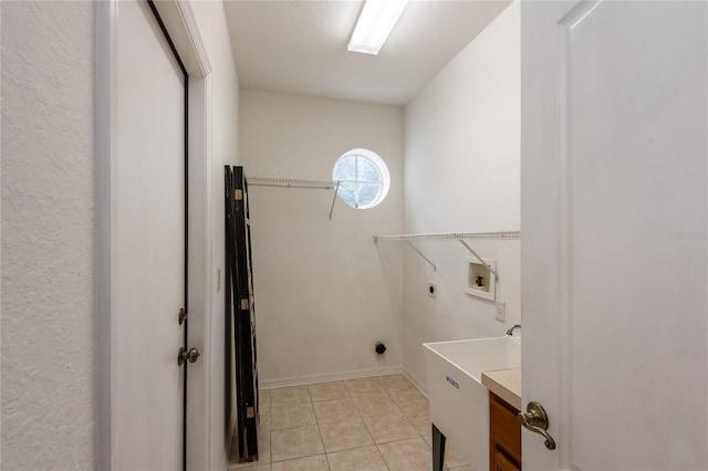 laundry area with electric dryer hookup, hookup for a washing machine, and light tile patterned floors