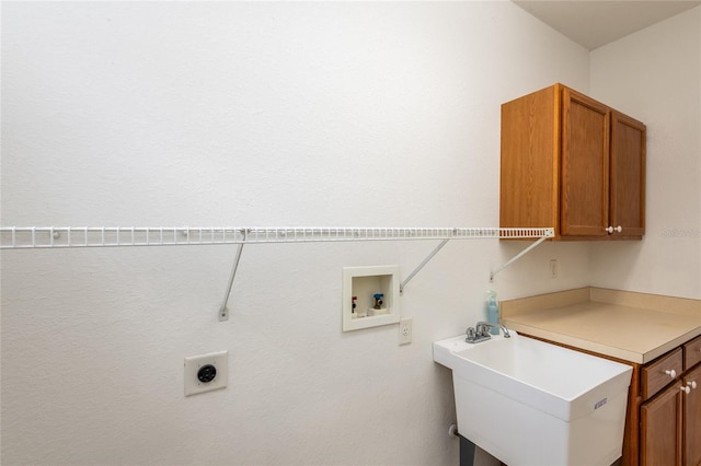 laundry area featuring hookup for a washing machine, hookup for an electric dryer, sink, and cabinets