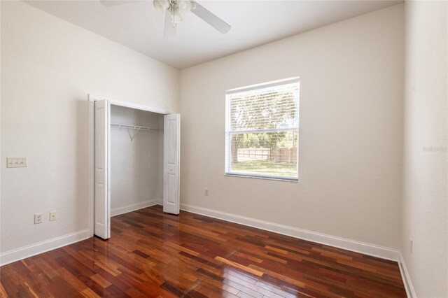 unfurnished bedroom with dark hardwood / wood-style floors, a closet, and ceiling fan