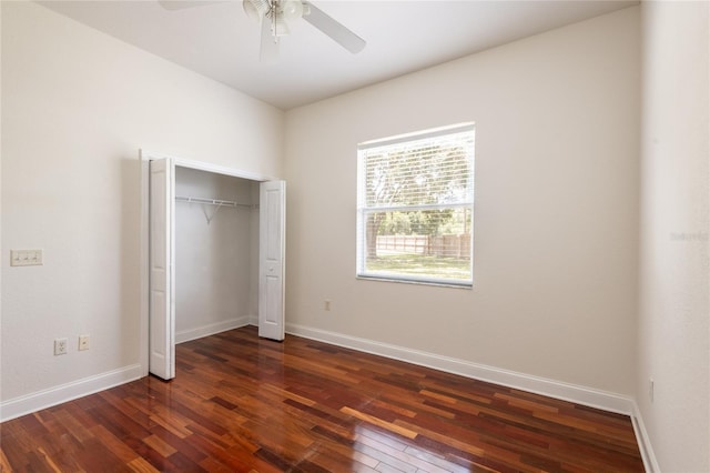 unfurnished bedroom featuring dark hardwood / wood-style floors, ceiling fan, and a closet