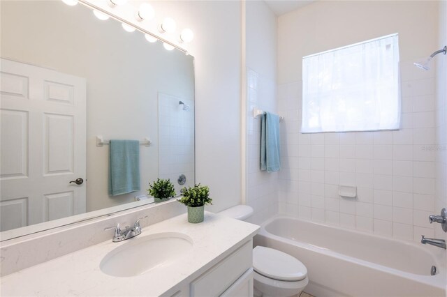 full bathroom with tiled shower / bath combo, toilet, and vanity