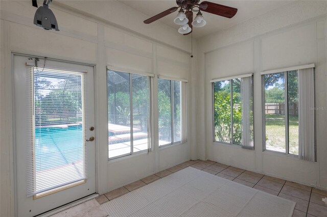 unfurnished sunroom with ceiling fan