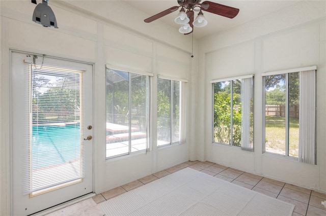 unfurnished sunroom with ceiling fan