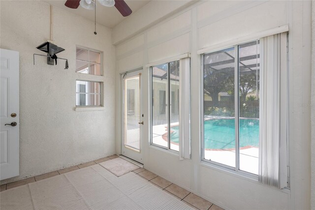 unfurnished sunroom featuring ceiling fan