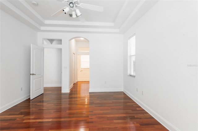 spare room featuring a raised ceiling, hardwood / wood-style floors, and ceiling fan