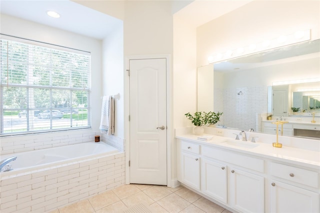 bathroom with vanity, tiled tub, and tile patterned flooring