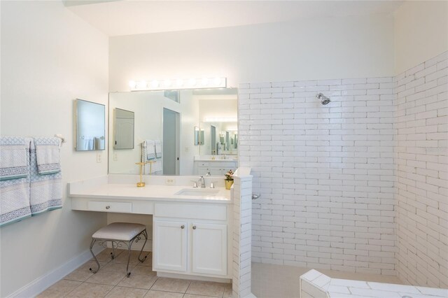 bathroom featuring tile patterned floors, vanity, and a tile shower