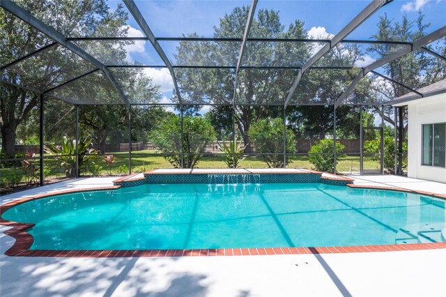 view of swimming pool featuring a patio area, glass enclosure, and a lawn