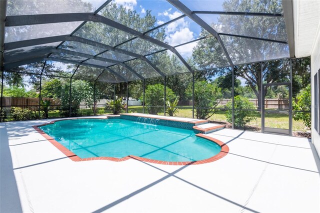 view of pool with a patio area and glass enclosure