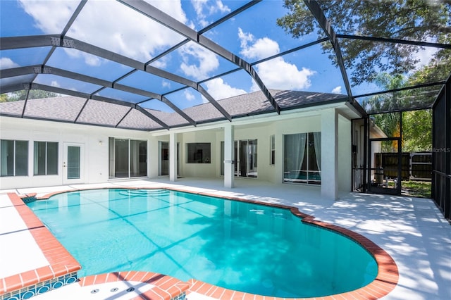 view of swimming pool with a patio area and a lanai