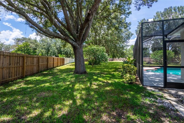 view of yard featuring a fenced in pool and a lanai