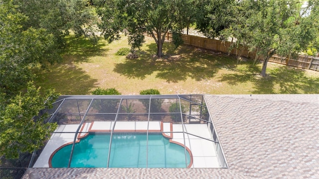 view of swimming pool featuring a lanai, a patio area, and a lawn