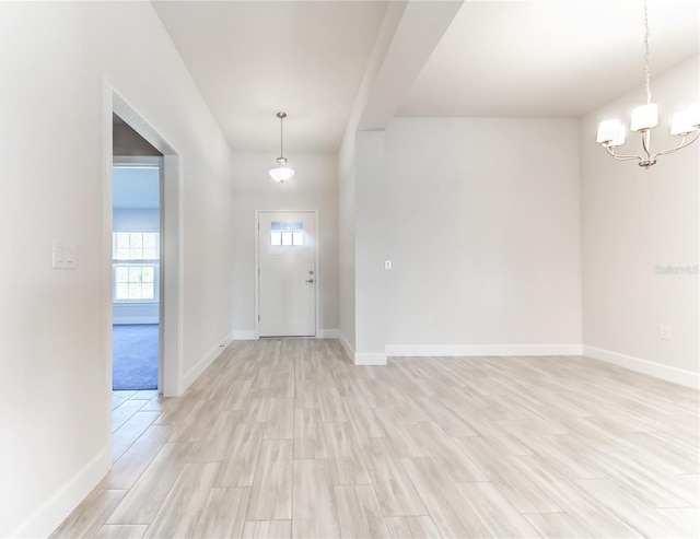 foyer entrance featuring light hardwood / wood-style flooring and a notable chandelier