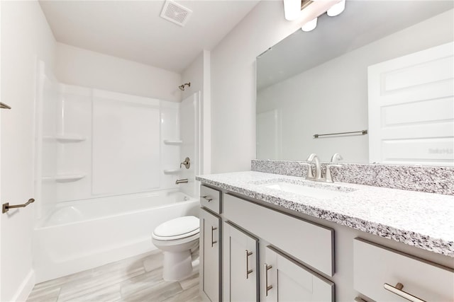 full bathroom with hardwood / wood-style floors, vanity, bathing tub / shower combination, and toilet