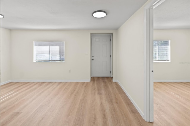 empty room with a healthy amount of sunlight and light hardwood / wood-style flooring