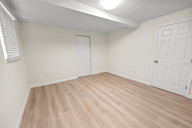 spare room featuring a textured ceiling and light wood-type flooring