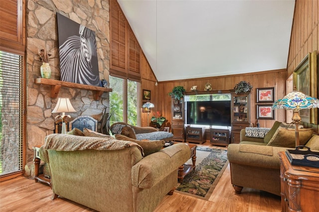 living room with wood-type flooring, wooden walls, and high vaulted ceiling