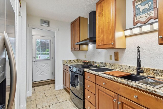 kitchen featuring wall chimney range hood, sink, black electric range oven, a textured ceiling, and light tile patterned flooring